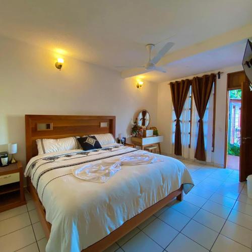 a bedroom with a large bed and a window at HOTEL MILIN in Villa Comaltitlán
