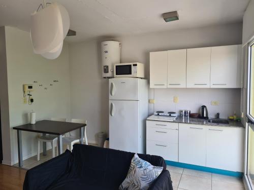 uma cozinha com um frigorífico branco e uma mesa em Departamento luminoso em Bahía Blanca