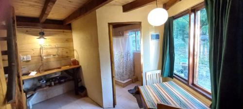 Un baño pequeño con lavabo y ventana. en Cafuné Cabañita Sur, en El Bolsón