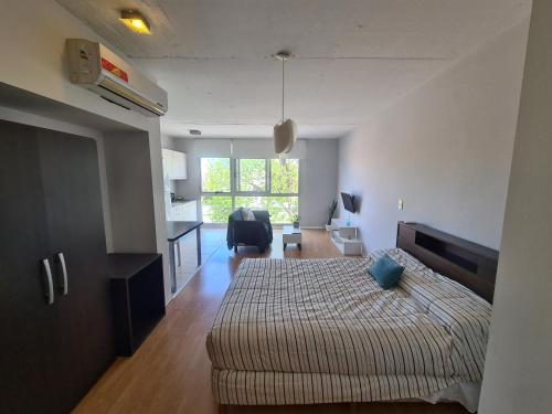 um quarto com uma cama e uma sala de estar em Departamento luminoso em Bahía Blanca