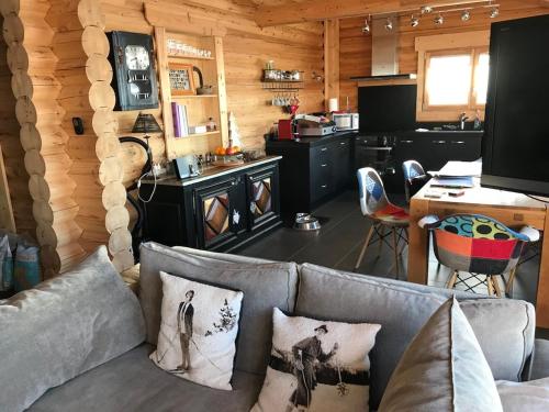 een woonkamer met een bank en een keuken bij Chalet Cervus in Font Romeu Odeillo Via