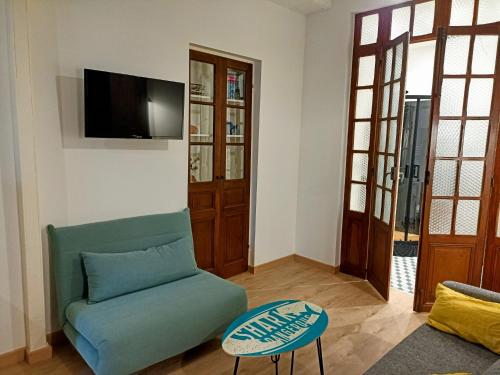- un salon avec un canapé vert et une télévision dans l'établissement Studio La Cabine, à Mers-les-Bains
