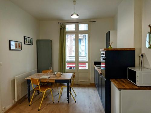 - une cuisine avec une table et des chaises dans la chambre dans l'établissement Studio La Cabine, à Mers-les-Bains