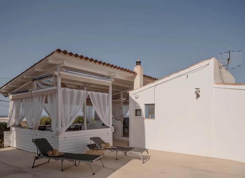 a patio with two chairs and a building at Molino Sa Miranda - Formentera Break in Sant Francesc Xavier