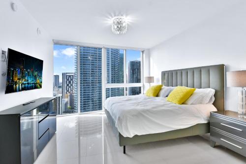 a white bedroom with a bed and a large window at Amazing 2 Bedroom at Icon in the Heart of Brickell in Miami