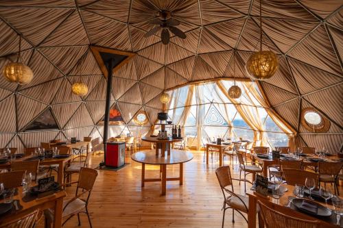 una sala da pranzo con tavoli e sedie in una yurta di Ecocamp Patagonia a Torres del Paine