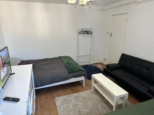 a living room with a bed and a couch at Wembley Homes Serviced Apartment, 25mins to Central London in Wembley