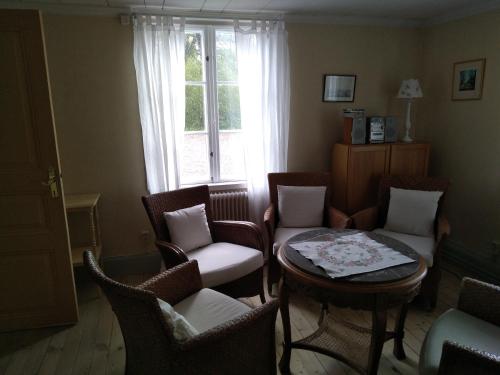 ein Wohnzimmer mit einem Tisch, Stühlen und einem Fenster in der Unterkunft Kristbergs Rusthåll in Borensberg