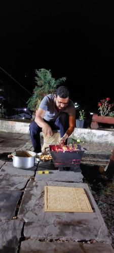a man preparing food on a stone table at Kurmanchal Village by THE GHAUR in Almora
