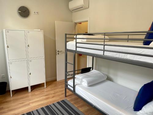 a dorm room with two bunk beds and a closet at Hostel Douro Backpackers in Pinhão