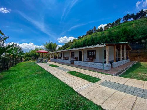 a house with a green hill behind it at Finca Palma de Coco, Municipio de el Peñol Antioquia in El Peñol