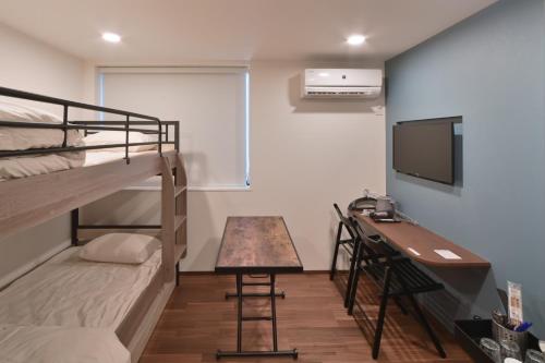a room with bunk beds and a desk and a television at Style Wood Nishi-Shinjuku 2nd floor 3rd floor - Vacation STAY 68984v in Tokyo