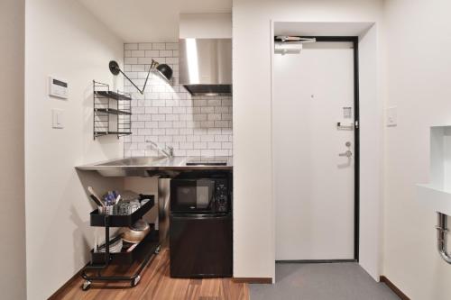 a small kitchen with a sink and a counter at Style Wood Nishi-Shinjuku 2nd floor 3rd floor - Vacation STAY 68984v in Tokyo