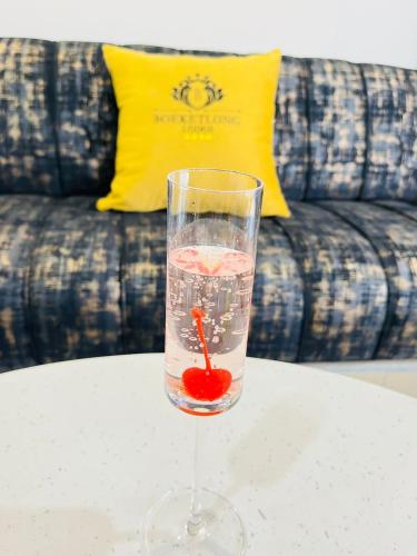 a glass of water on a table with a cherry in it at Boeketlong Lodge in Jane Furse