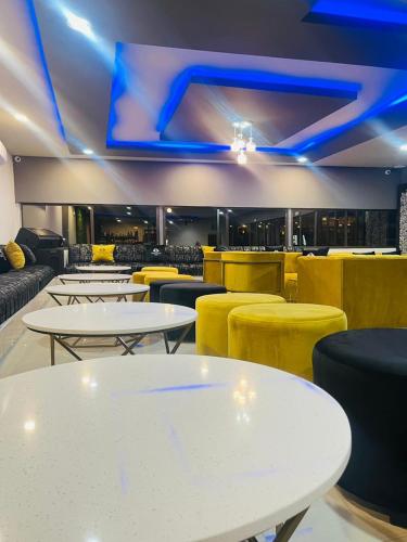a restaurant with white tables and yellow chairs at Boeketlong Lodge in Jane Furse
