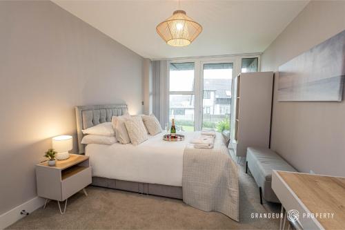 a bedroom with a large white bed and a window at Newly Built 2br Apartment near Sandy Beaches and Tuckton Village - Meraki Vista in Bournemouth