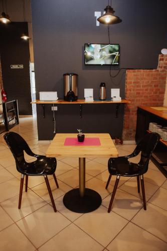 プエルトイグアスにあるISONDU Suites & Breakfastのテーブルと椅子2脚