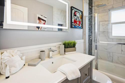 a white bathroom with a sink and a mirror at Royal Blue Dreams flexible rental near Anna Maria Island in Bradenton