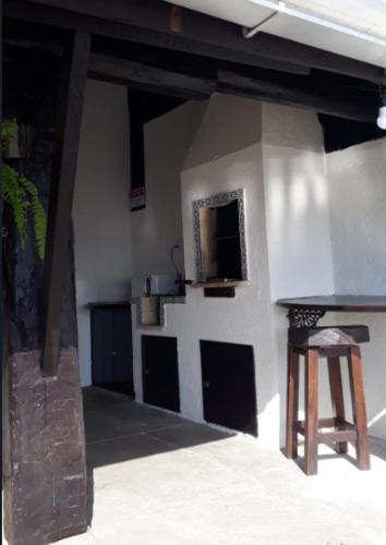 a room with a building with a counter and a stool at Pousada Caminho do Mar in Bombinhas