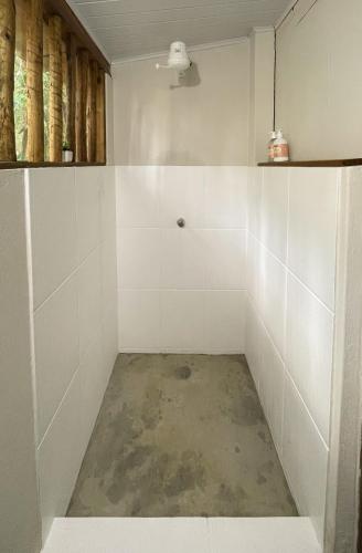 a room with white tiled walls and a concrete floor at OLITAS - Praia de algodões in Marau