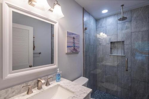 uma casa de banho com um chuveiro, um lavatório e um espelho. em 3414 Carolina Place em Hilton Head Island