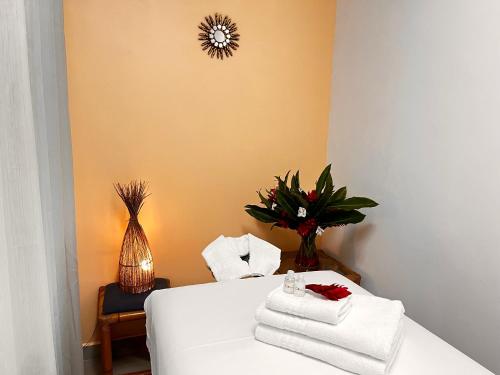 a room with a bed with towels and a clock on the wall at Ciribaí Praia Hotel in Pauba