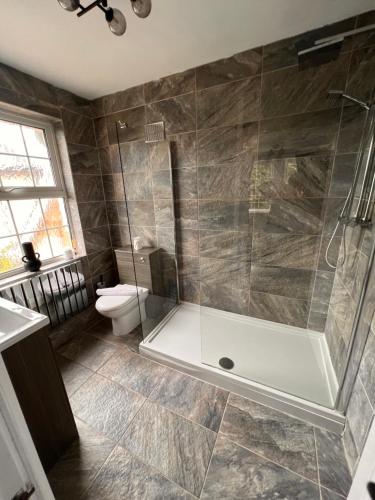 een badkamer met een douche en een toilet bij A beautiful Large 7 bed house in Porthcawl