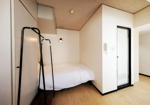 una piccola camera con letto e specchio di ＰＩＡＺＺＡーＵ - Vacation STAY 77958v a Tokyo