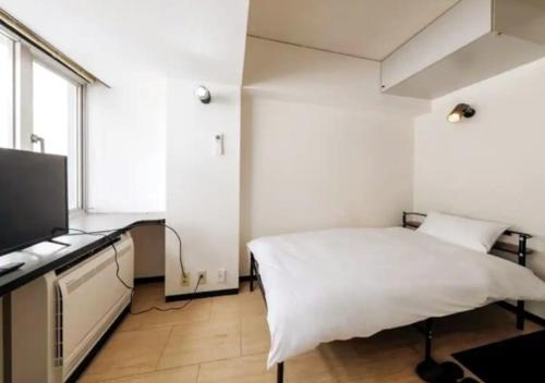 a bedroom with a bed and a flat screen tv at ＰＩＡＺＺＡーＵ - Vacation STAY 78015v in Tokyo