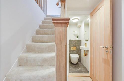 a bathroom with a staircase with a toilet and a sink at Charming Winchester Retreat in Winchester