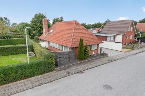 a house with a red roof on a street at BB Ikast in Ikast