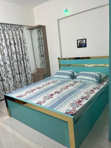 a bedroom with a bed with a blue bed frame at Little nest Homestay in Pune