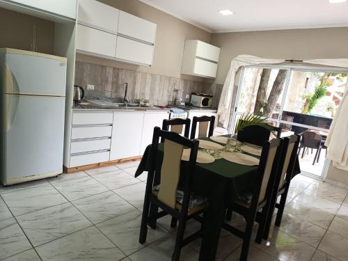 een keuken met een tafel en een witte koelkast bij Hotel Village del Sol in Puerto Iguazú