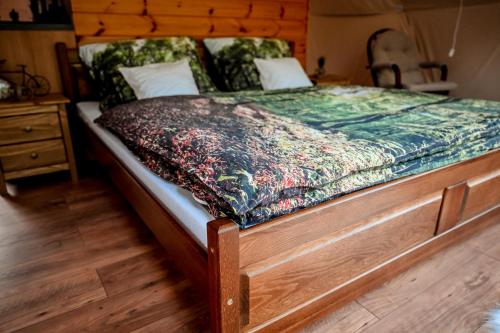 1 dormitorio con 1 cama con marco de madera en Glamping Meleček, en Opava