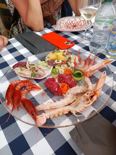 a plate of shrimp and other foods on a table at "Appartamento del Mare Gliaca" con vista Isole Eolie,ampia terrazza,wifi e parcheggio gratuito in Piraino