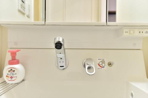 a white kitchen with a sink and a mirror at Monotone Nanba - Vacation STAY 15469 in Osaka