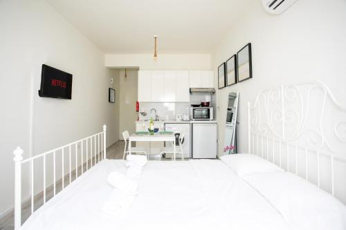 a white kitchen with a white bed in a room at Palmove Makenzie Studio 4 in Larnaca