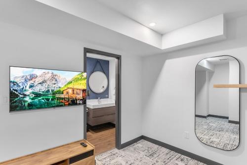 a bathroom with a mirror and a tv on the wall at Cannery Lofts Niagara in Niagara Falls