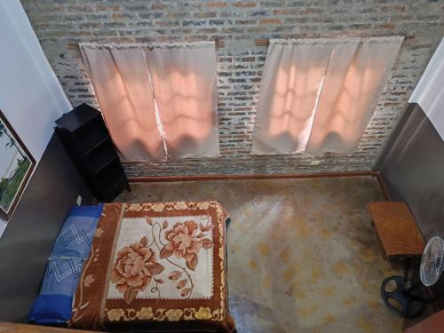 a room with two windows and a bed with a rug at Hotel Village del Sol in Puerto Iguazú