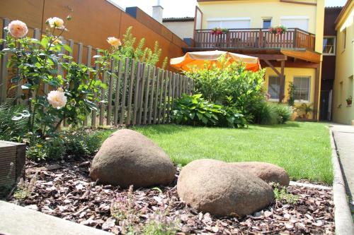 a garden with two large rocks in a yard at Gästehaus Lokalaugenschein in Podersdorf am See