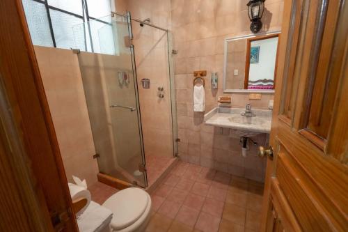 a bathroom with a shower and a toilet and a sink at Hotel Rincon de Josefa in Pátzcuaro