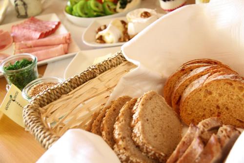a basket of bread on a table with other foods at Gästehaus Lokalaugenschein in Podersdorf am See