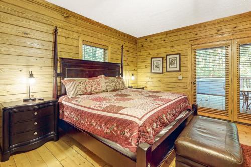 ein Schlafzimmer mit einem Bett und einer Holzwand in der Unterkunft Woodland Hideaway in Gatlinburg