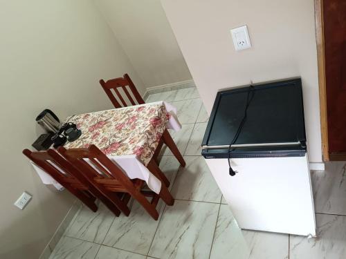 a kitchen with a table and a chair and a refrigerator at Hotel Village del Sol in Puerto Iguazú