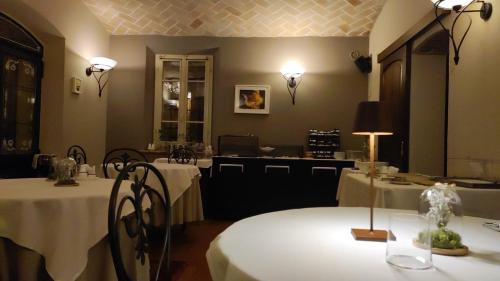 a dining room with two tables with white table cloth at Locanda Del Feudo Suite & Restaurant in Castelvetro di Modena