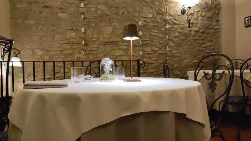 a table with a white table cloth and a lamp at Locanda Del Feudo Suite & Restaurant in Castelvetro di Modena