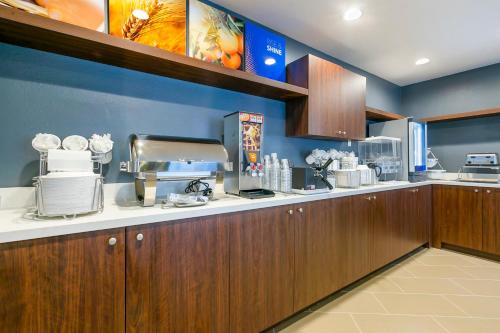 a kitchen with wooden cabinets and a counter top at Comfort Inn & Suites Houma in Houma