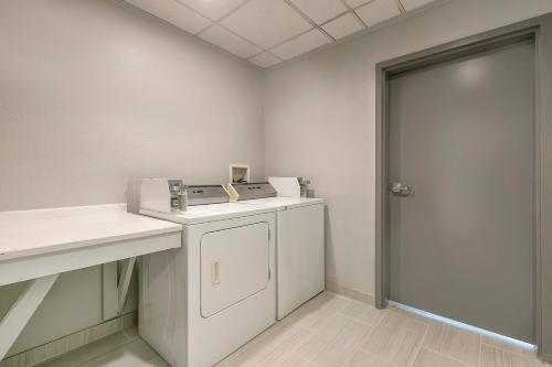 a laundry room with a washing machine and a door at Comfort Inn & Suites Houma in Houma
