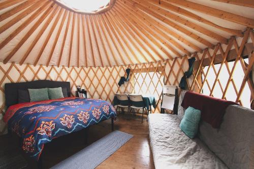 a bedroom in a yurt with a bed and a couch at Shearwater Cove in Seward