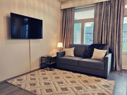 a living room with a couch and a flat screen tv at Rovaniemi Cityhome Sunnarborg in Rovaniemi